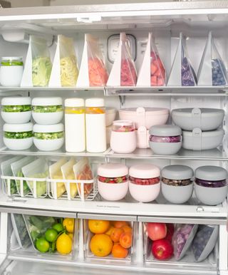 A fridge organized with colorful food in containers