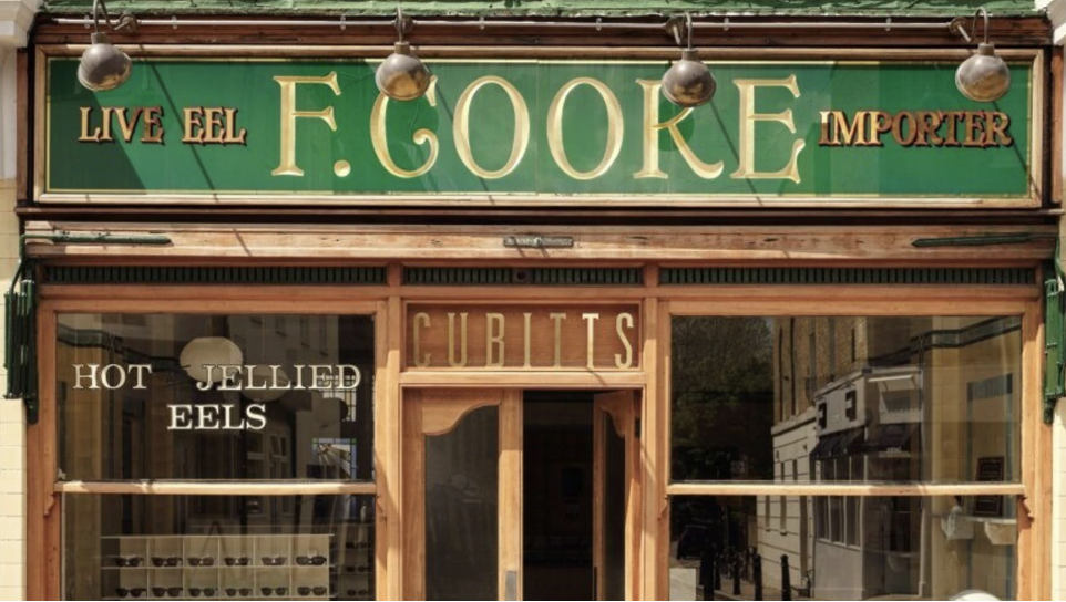 an image of the exterior of the F. COOKE pie and mash shop with its iconic green sign above the door