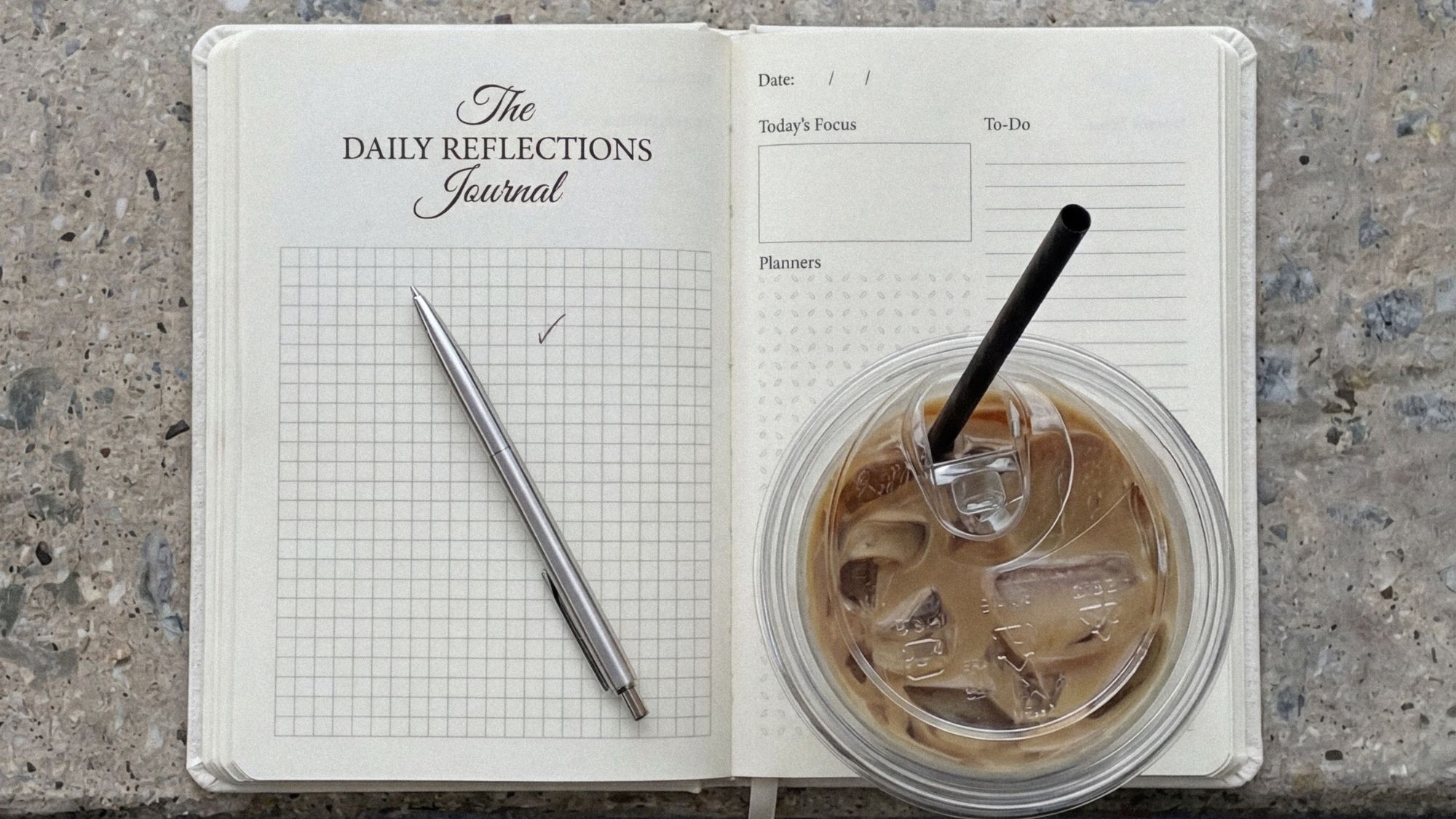 daily reflections wellness journal open with an iced coffee