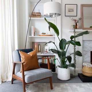 white living room with grey armchair tall houseplant