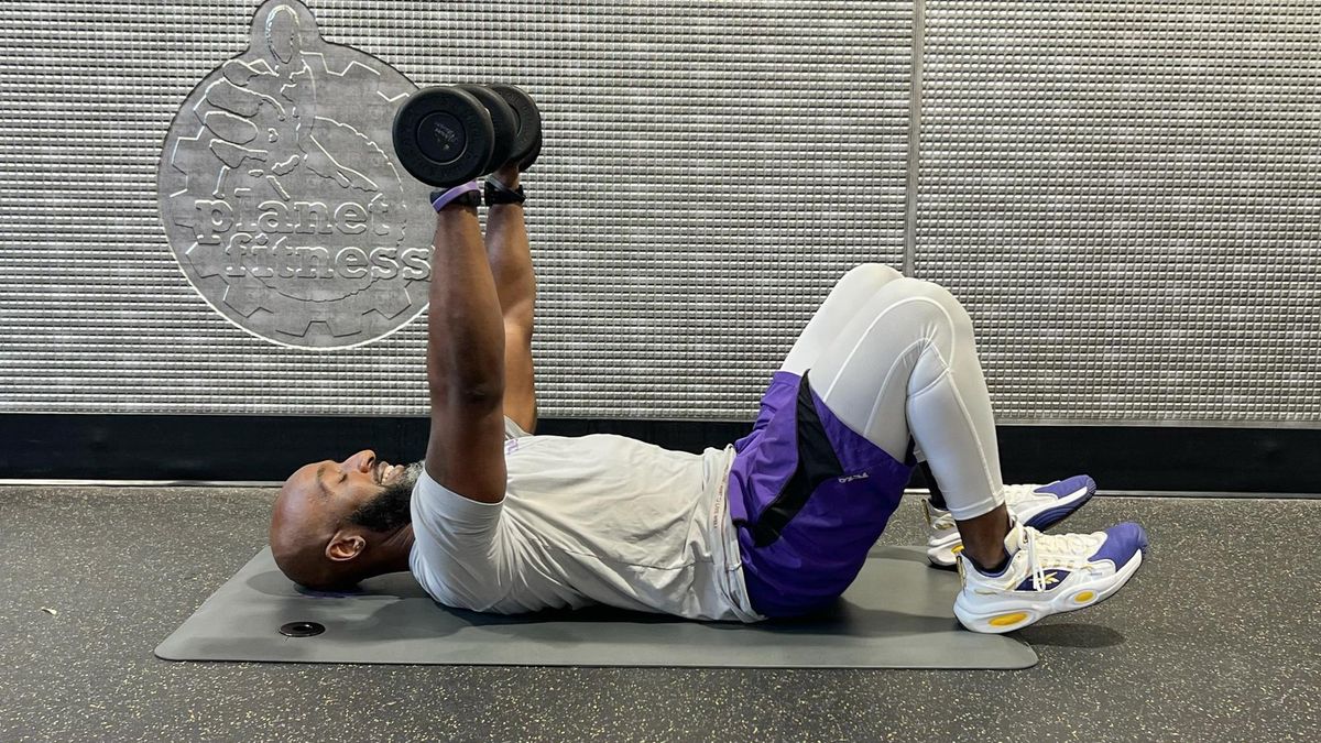 Teddy Savage performing a dumbbell floor chest press to triceps skull crusher