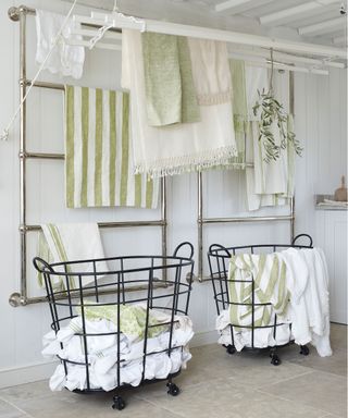 How to organize a laundry room with wall mounted drying racks, in a white scheme with pale green accents.