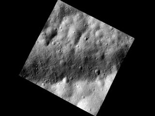 This close-up photo of the asteroid Vesta taken by NASA’s Dawn spacecraft shows a part of one of the troughs at the equator of the asteroid. In the image, the floor of one of the equatorial troughs appears as the brighter deposit at the bottom of this image, contrasted against the darker band of the trough edge.