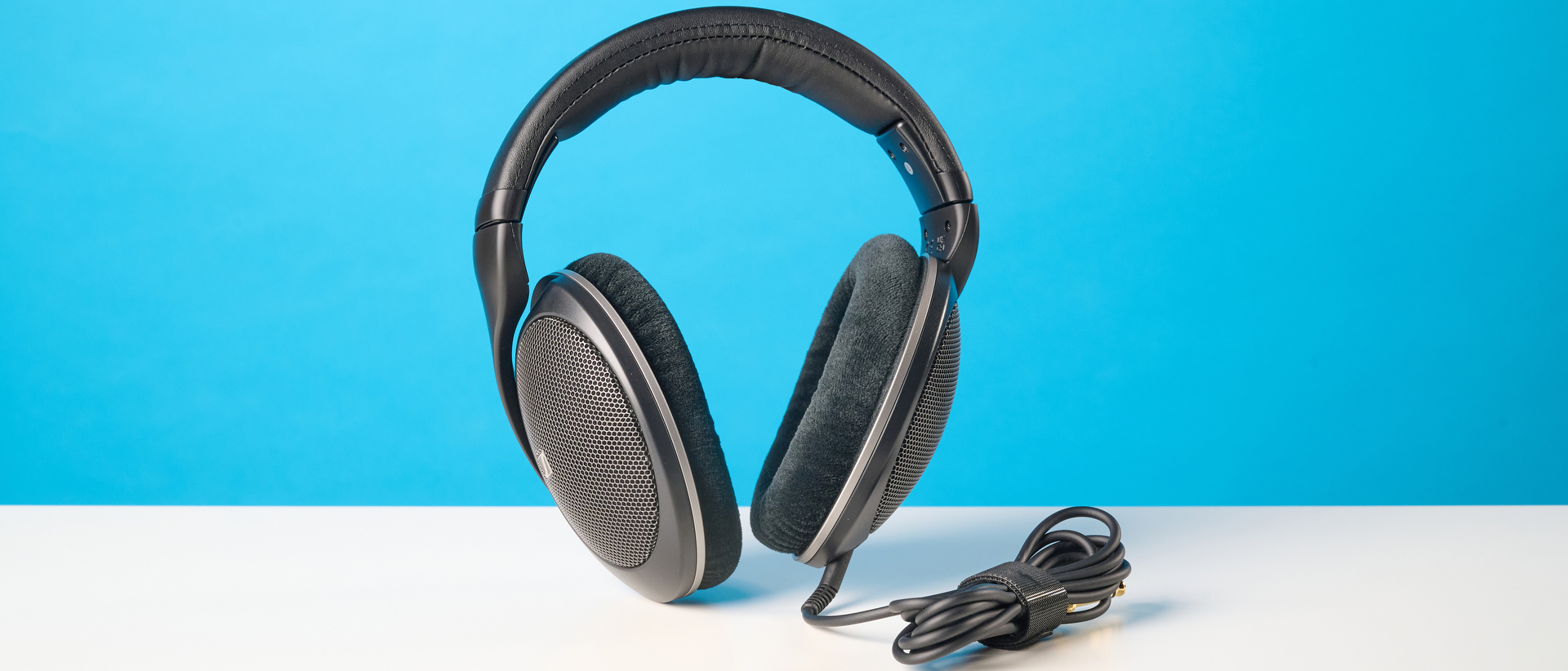 The Sennheiser HD 550 headphones on a stone surface with a blue background