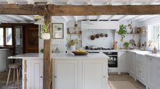 A white cottage style kitchen with wooden beams 