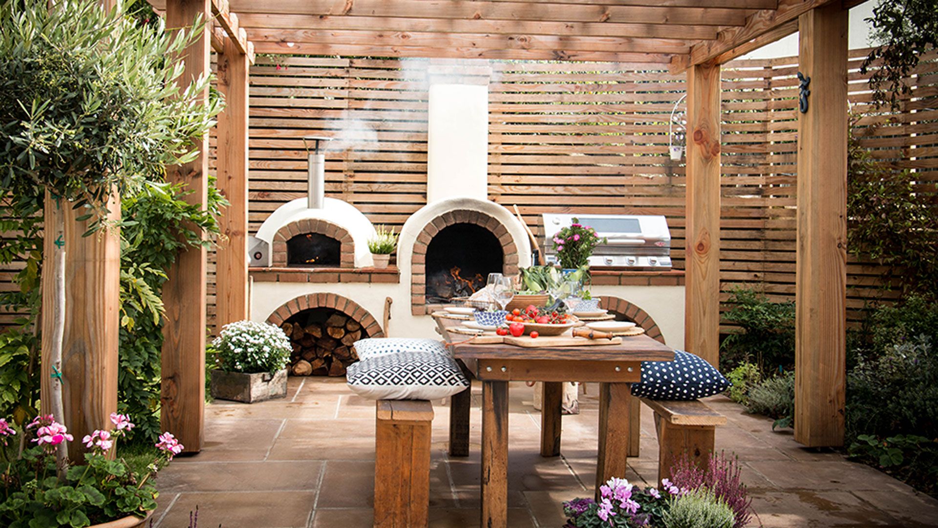 Outdoor kitchen ideas with timber pergola and pizza oven