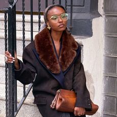 a woman wearing a fur trim coat