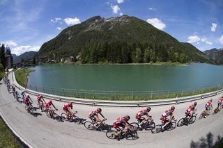 The peloton passes a lake on stage 14 of the Giro d'Italia (Sunada)