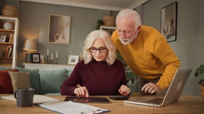a couple at a kitchen table discussing financial decisions