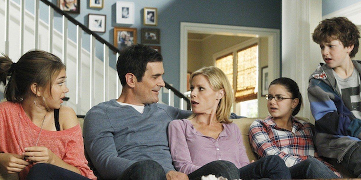 Some of the cast of _Modern Family_ at the Dunphy house on their couch.