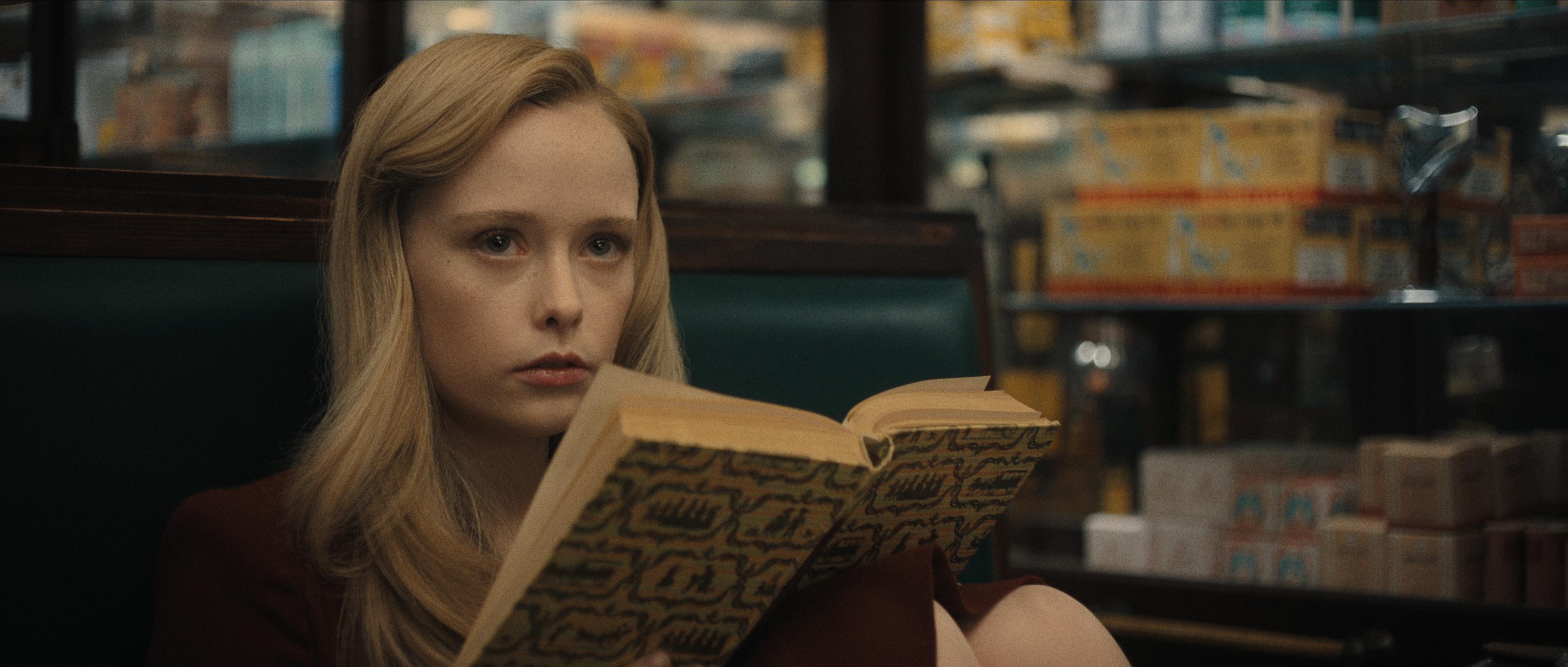 suzanna son as Adelina reading a book in a booth in monster the ed gein story