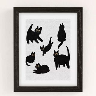 A framed print from Urban Outfitters with black cats