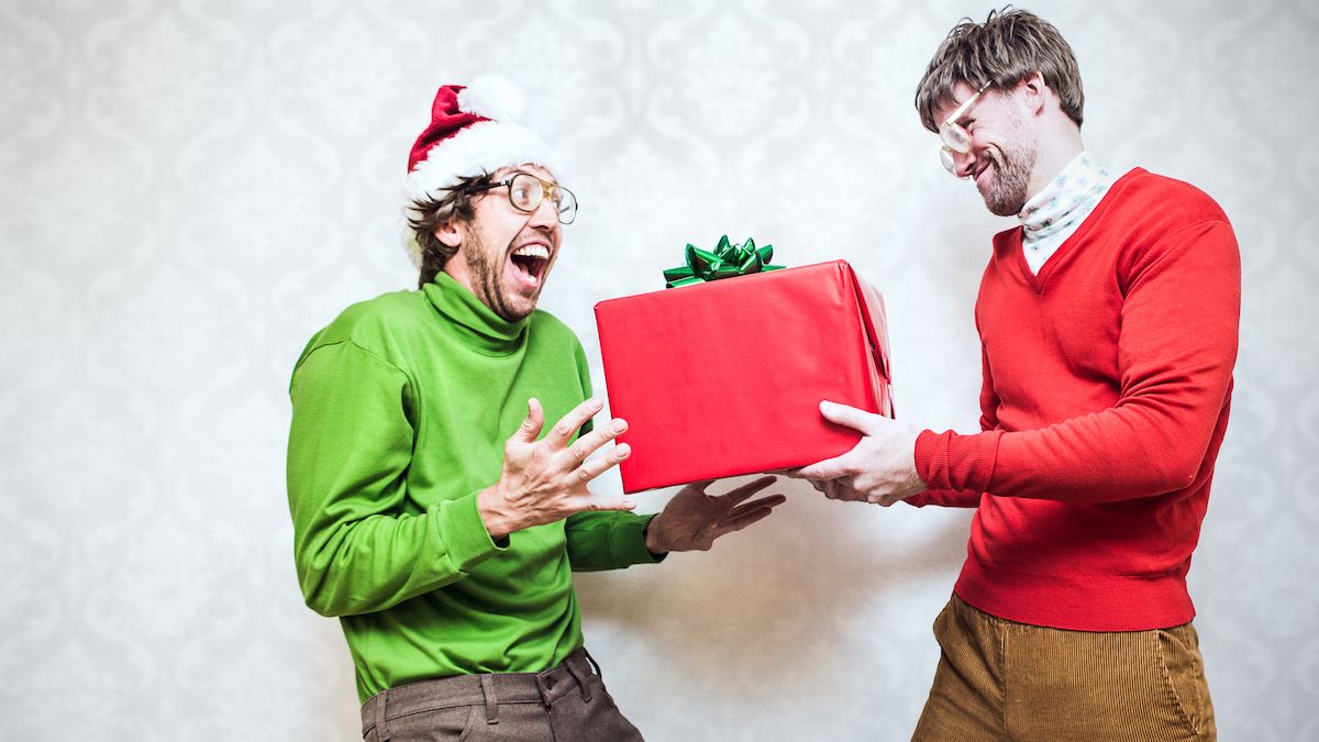 Man in green jumper received a gift from a man in a red jumper