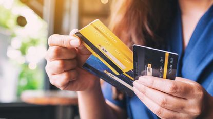 A woman holding several credit cards