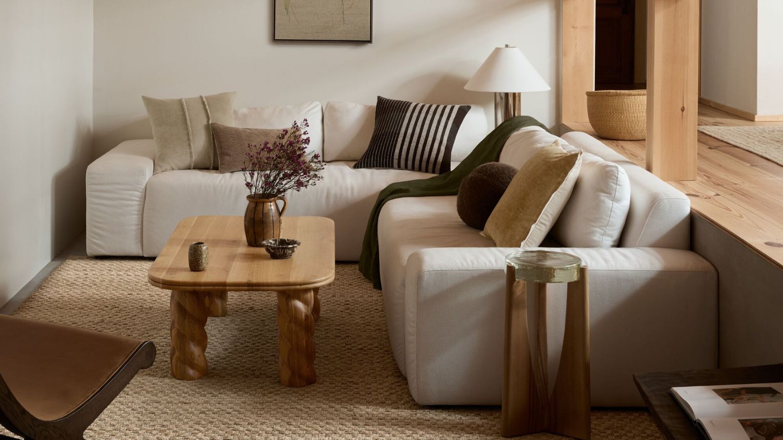 modern organic living room by Joon Loloi with a white modular couch and warm wooden coffee table