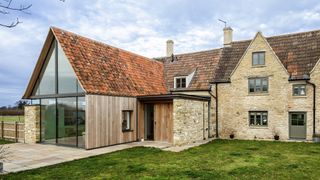 stone cottage with large modern extension and porch extension clad in stone