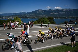 Jumbo-Visma's Danish rider Jonas Vingegaard wearing the overall leader's yellow jersey cycles with the pack past the Lac du Bourget during the 18th stage of the 110th edition of the Tour de France cycling race, 184 km between Moutiers and Bourg-en-Bresse, in the French Alps, on July 20, 2023. (Photo by Marco BERTORELLO / AFP)