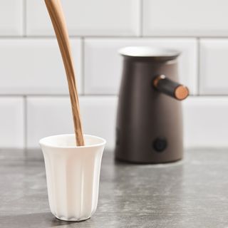 Hotel Chocolat Velvetiser pouring hot chocolate into white mug