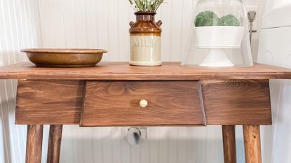 wooden console table with drawer and decorative pieces 