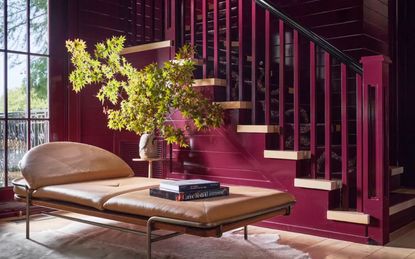 Staircase painted in red gloss paint with dark patterned runner