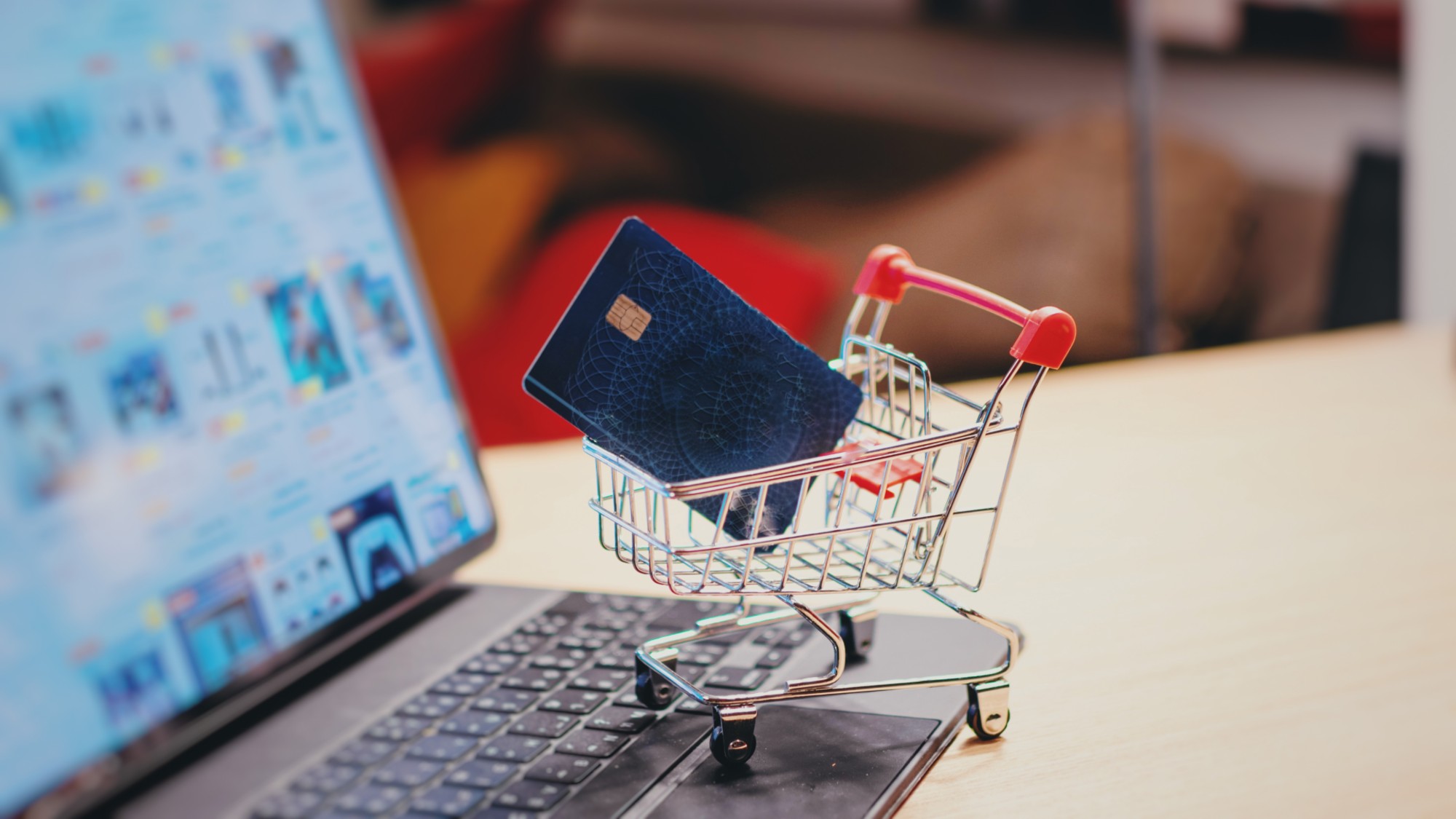 A stock photo of a mini shopping cart and a laptop. 