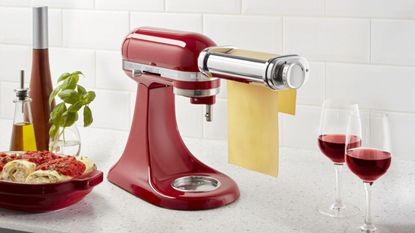 One of the best KitchenAid attachments the KitchenAid pasta roller attachment making a sheet of pasta with two glasses of red wine beside it