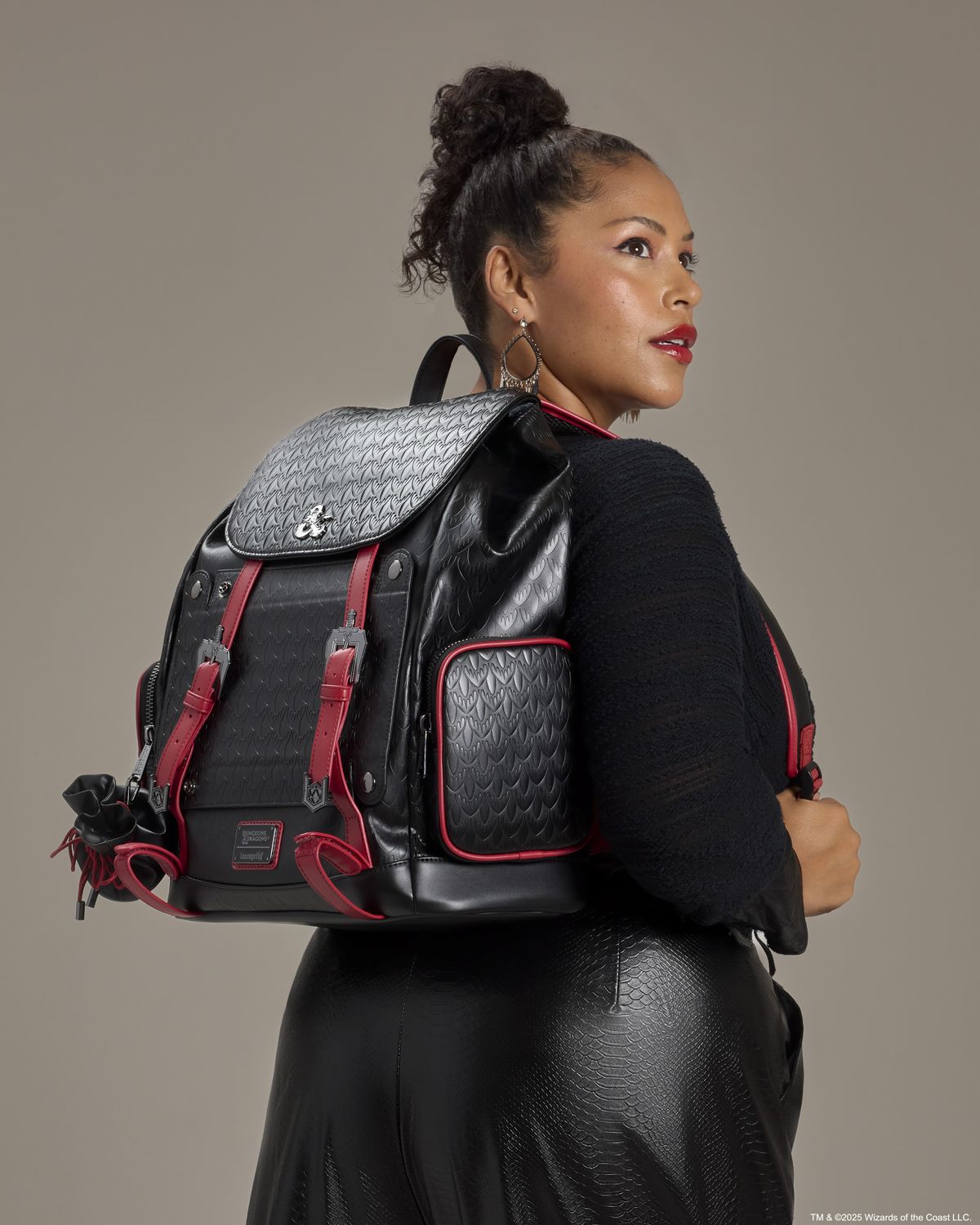 A woman wearing the Loungefly D&amp;D backpack looks off to the right of frame