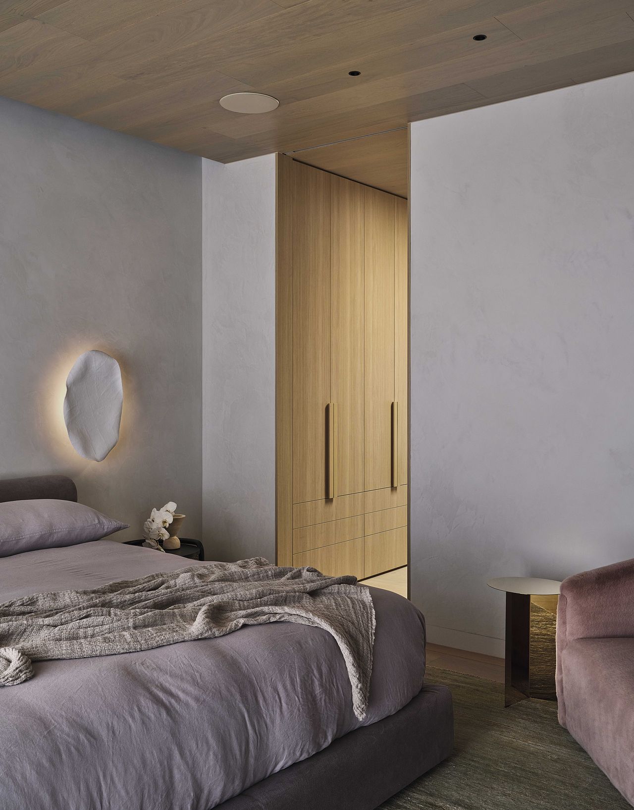 A view of a bedroom with a glimpse of an open doorway leading to a walk-in wardrobe