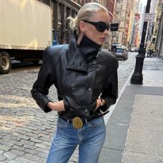 Woman in a leather jacket, jeans, and big-buckle belt