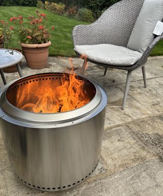 Solo Stove 2.0 Bonfire Fire Pit alight on stone patio