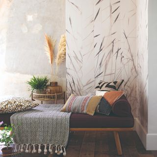 A living room with a daybed and a botanical wallpaper