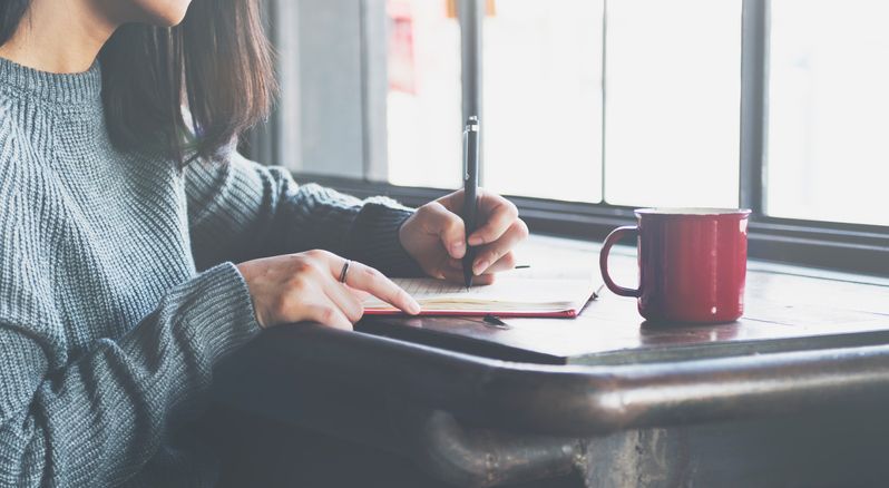 A woman writes a letter.