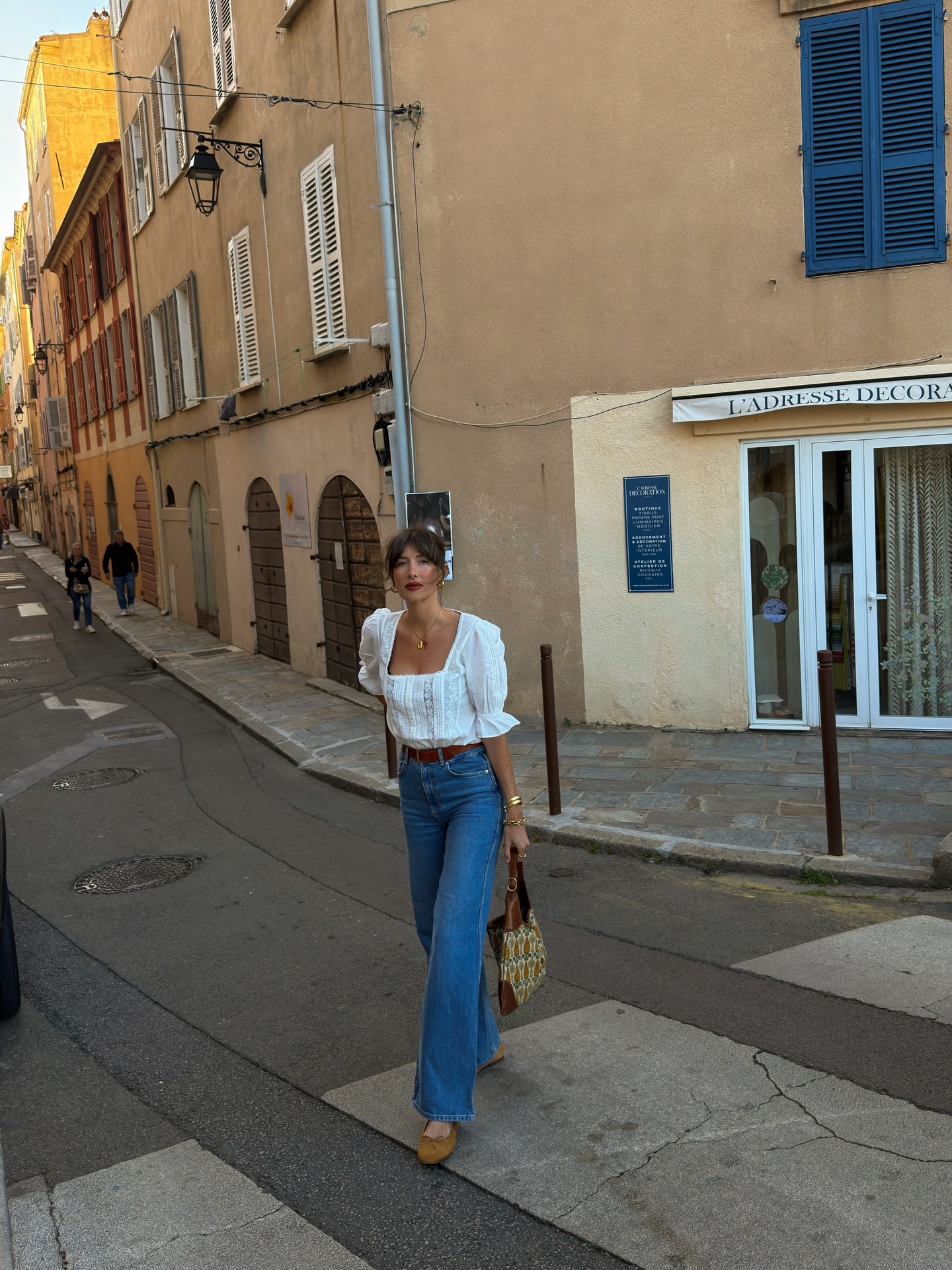An image of a woman wearing a blouse and jeans summer outfit 2026