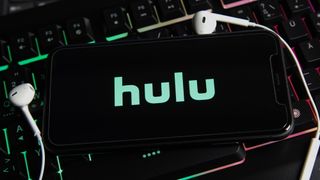 Hulu logo on smartphone, resting on a lit up gaming keyboard