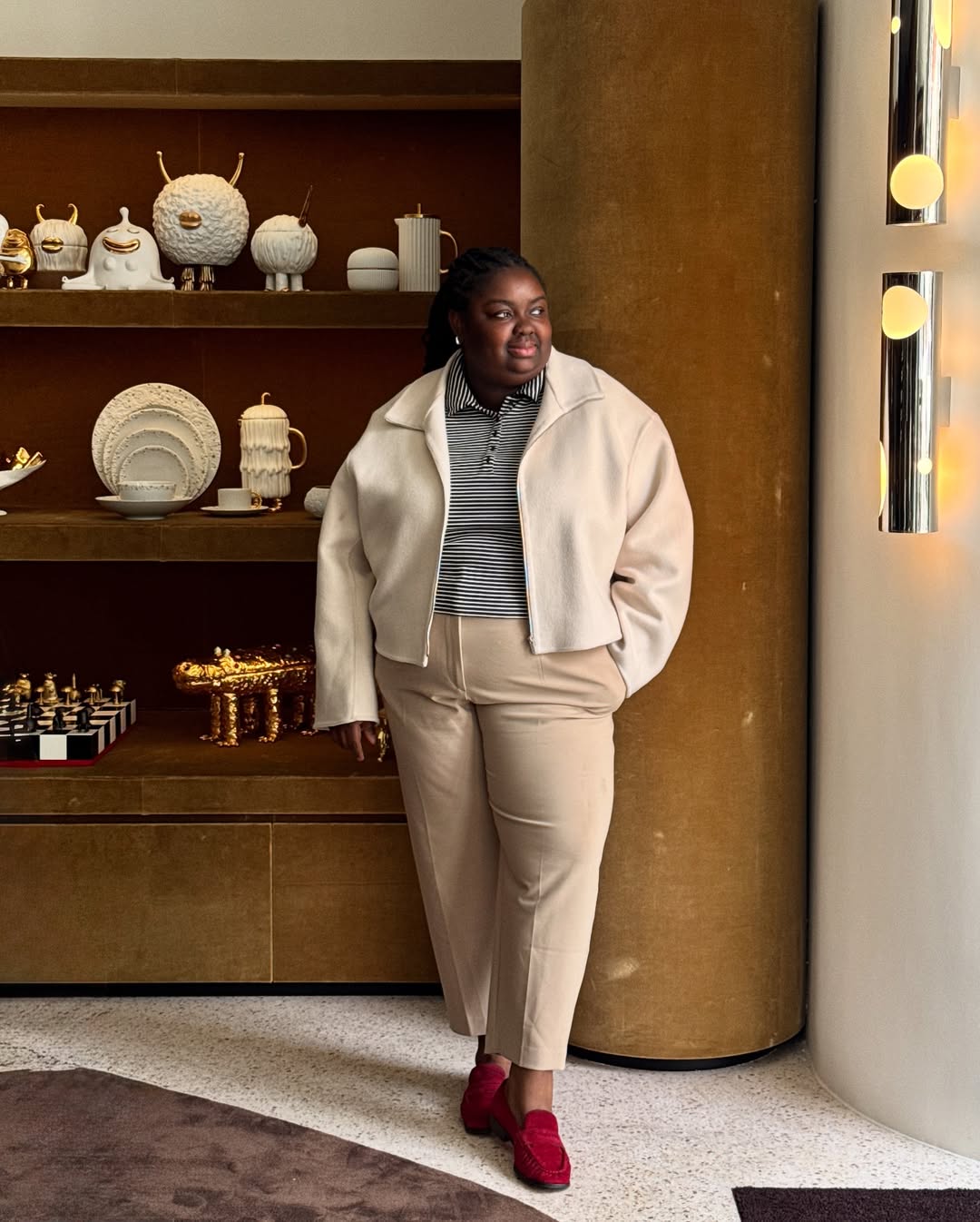 Abisola in cropped trousers, jacket and red loafers