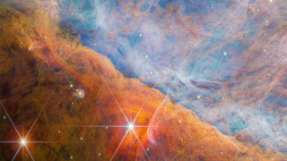 A beautiful starscape of orange and blue gas filled with twinkling stars