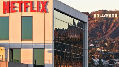 An aerial view of the Netflix logo displayed at Netflix studios, with the Hollywood sign in the distance on December 5, 2025 in Los Angeles, California