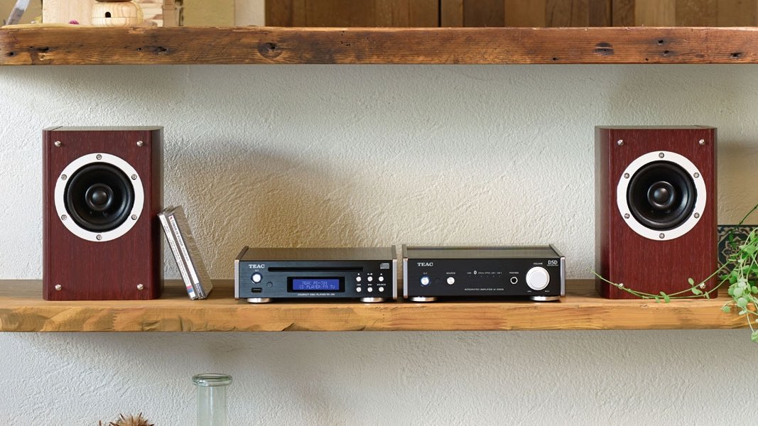 Teac Pd 301 Cd Player in black on a shelf next to speakers and other audio compnent