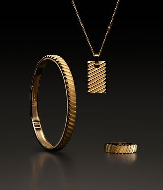 Gold ridged mens Dunhill jewellery against a black background