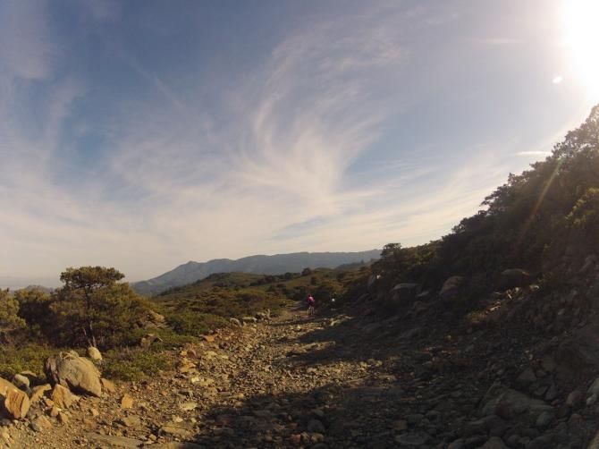 Mary McConneloug descends a rocky ridge with Mt. Tamalpais in the distance