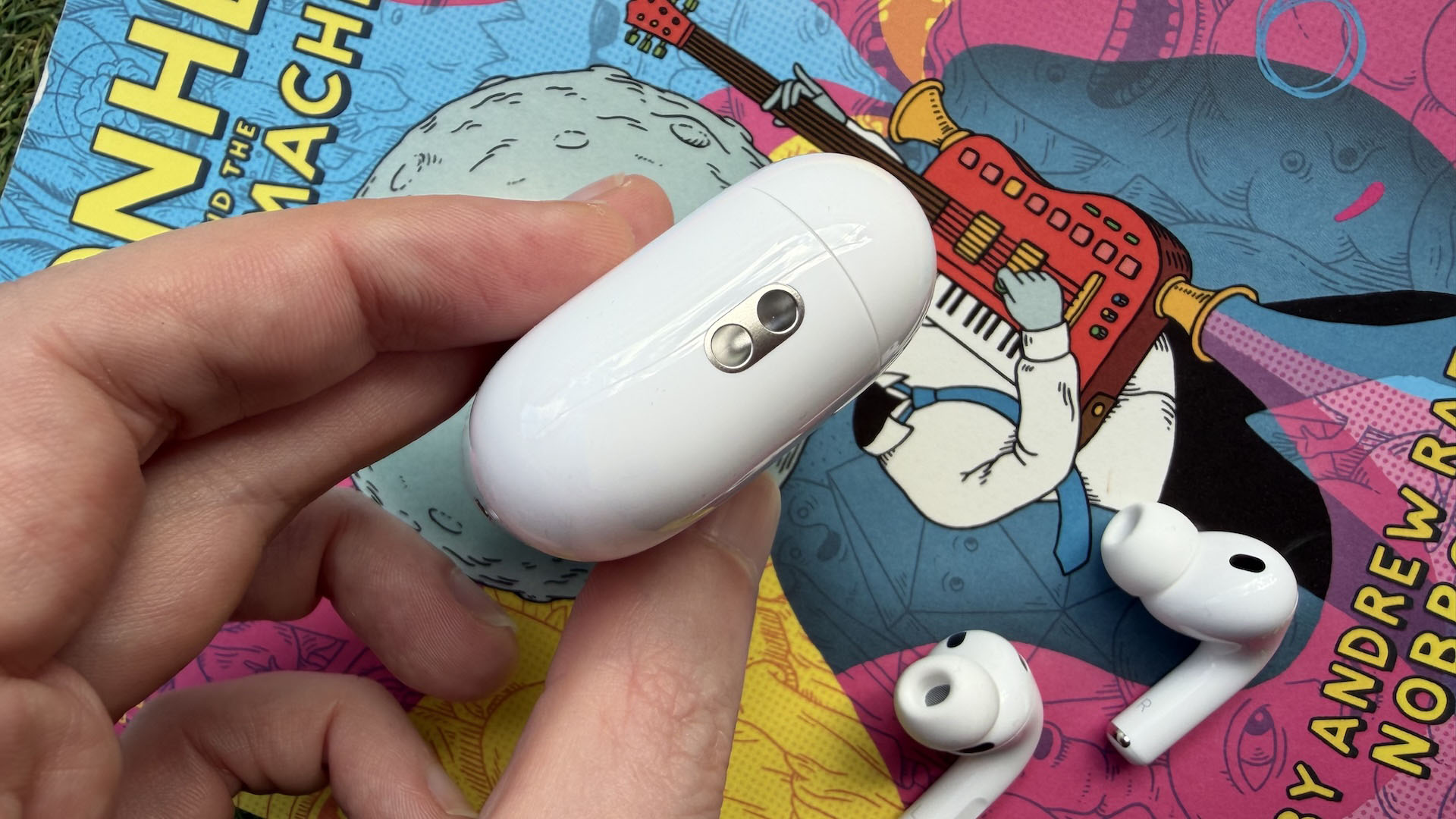 The AirPods Pro 3 earbuds from Apple against the pages of a graphic novel.