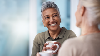 Woman talking to friend over coffee