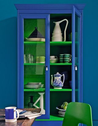 A royal blue cabinet with green shelving