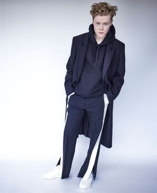 Kai Alexander wearing a navy hoodie styled with a matching blazer and pants.
