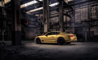 Bentley Continental GT Speed in gold side view in a warehouse