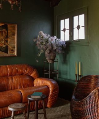 dark green painted snug small living room with wooden panelled ceiling and vintage furniture