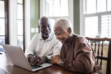 Senior couple using laptop at home triple lock