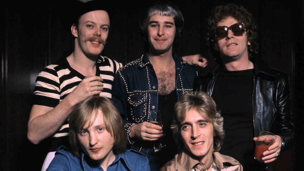 Mott The Hoople posing for a photograph with new guitarist Mick Ronson in 1975