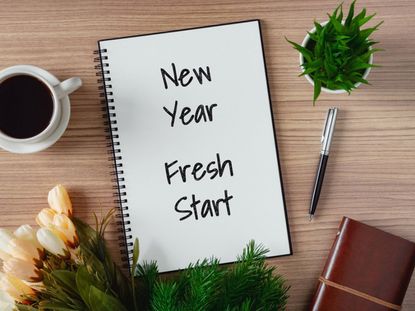 New Year Fresh Start Notebook On Table With Coffee Pen And Plants