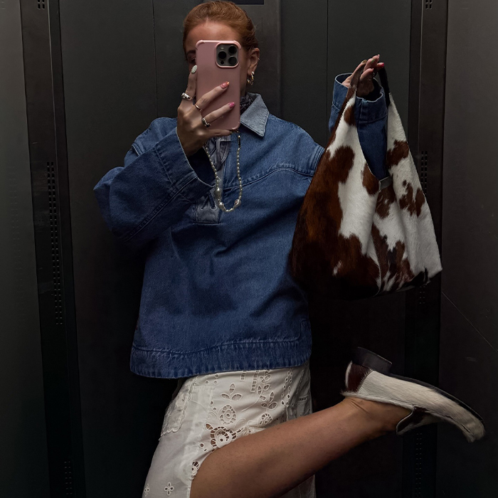 rebecca wears denim jacket and white skirt with callf hair handbag and shoes and rebecca wears yellow top and plaid skirt outfit while taking a mirror selfie